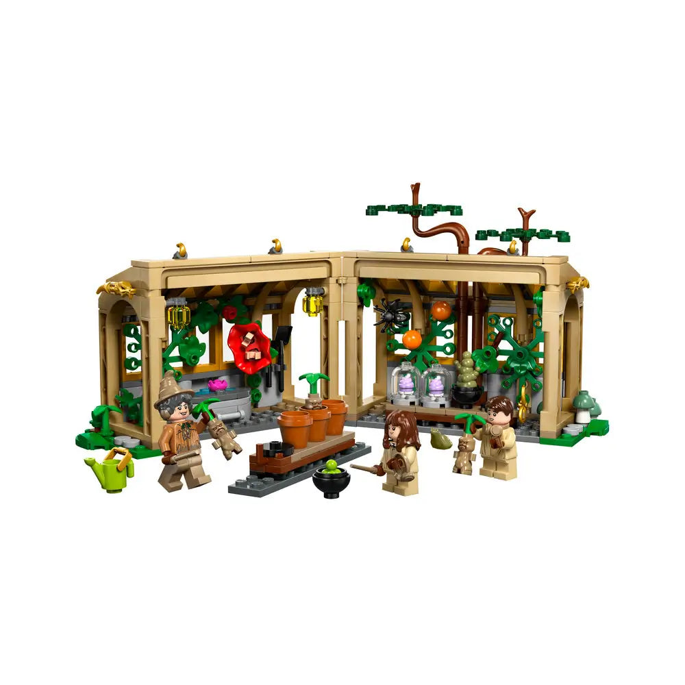 LEGO Harry Potter Herbology Class playset features a tan plastic greenhouse with green plants, magical accessories, Professor Sprout, Hermione and Neville on a clean white background with detailed LEGO elements and realistic display presentation.