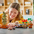 LEGO Harry Potter Hogwarts Herbology Plants play scene shows a smiling child with green and red brick plants in brown pots, including a Mandrake and Mimbulus Mimbletonia.