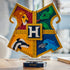 LEGO Harry Potter Hogwarts House Crest in gold-trimmed plastic bricks, with red lion, green snake, yellow badger and blue eagle panels displayed upright on a black stand.