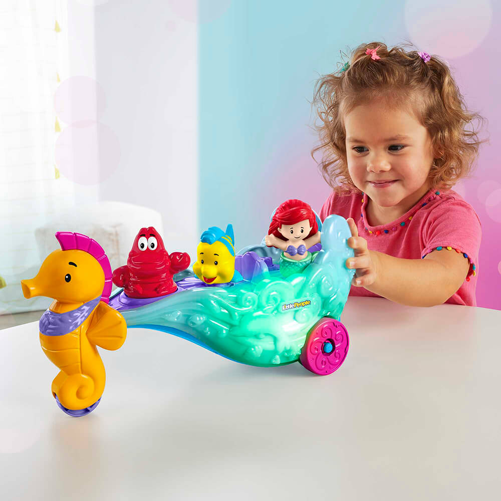 Little girl playing with the Little People Disney Princess Ariel's Light-Up Sea Carriage Playset
