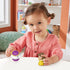 Disney Princess Belle toy play scene by Fisher-Price Little People with child holding yellow Belle figure and white teapot Mrs. Potts, colorful nursery background with shelves and soft lighting