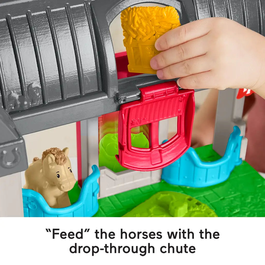 Close-up of Fisher-Price Little People Friendly Horses Stable showing hay bale being dropped through the red chute to feed the horses.