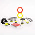 Magshuto Stunt Park components in neon yellow, black, and gray plastic laid out as curved ramps, hexagon frames, launch pads, and round discs, displayed across a white tabletop to show the full set.