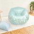 Light green inflatable 3C4G Fairy Garden Chair placed in a cozy bedroom setting with wooden floors, a white rug, and a soft blue pillow beside it.
