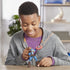 Smiling child in a gray hoodie and purple shirt playing with a Marvel Captain America Bend and Flex figure on a wooden table, bending the toy’s arms while posing it with the iconic shield.