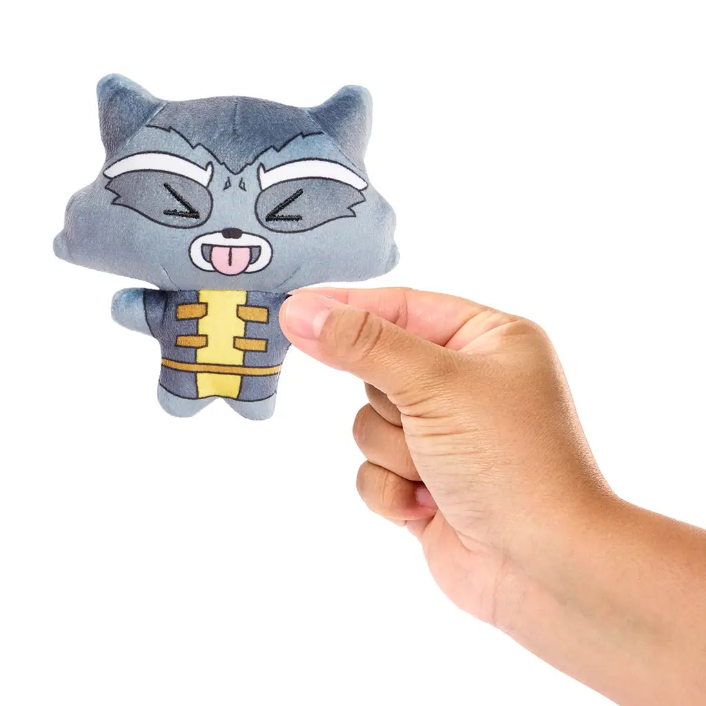 Hand holding Marvel Rocket Moodiverse plush, showing compact 4-inch soft toy with embroidered face details, tongue-out expression, and gray and yellow costume for fans and kids.