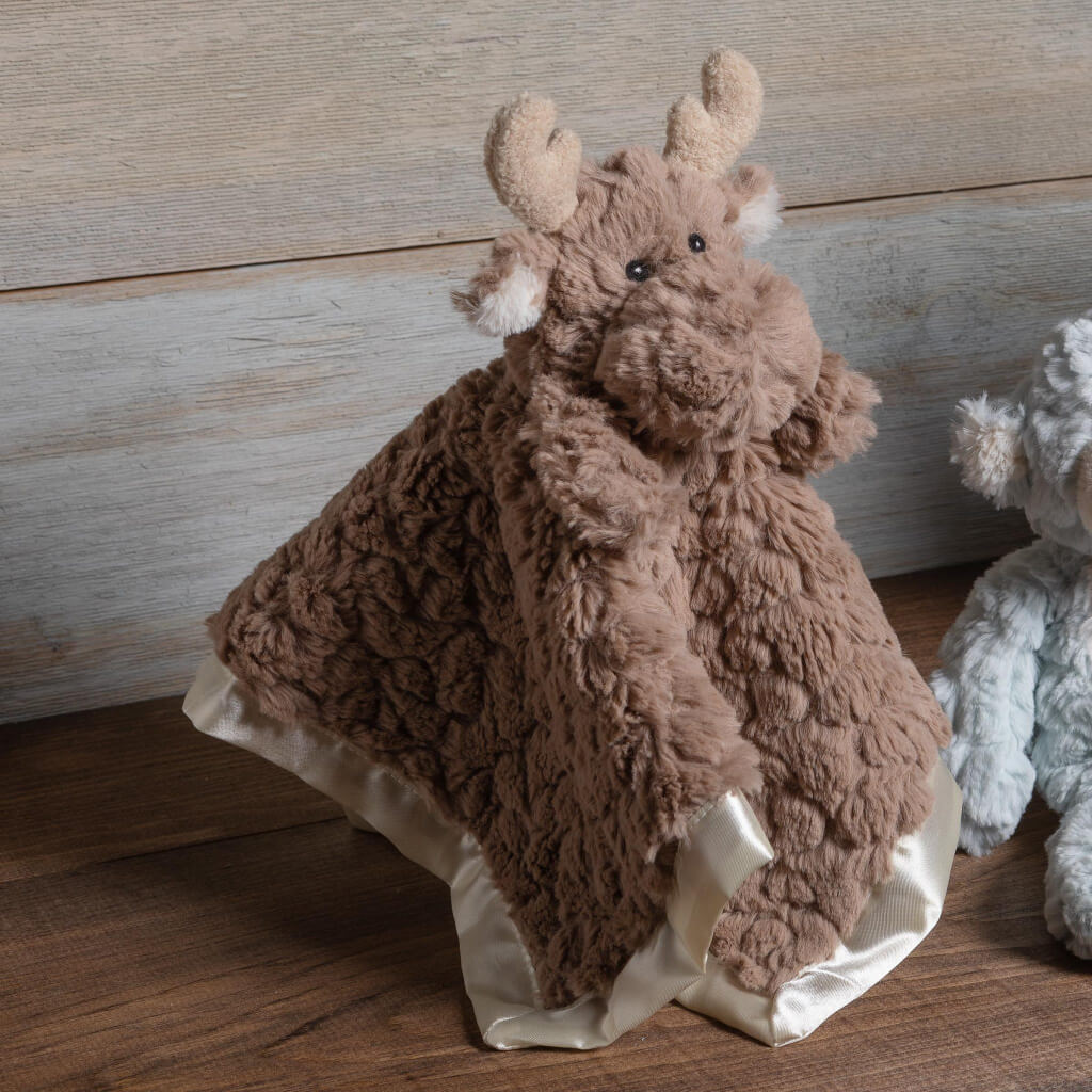 Moose character blanket sitting on display with a brown table