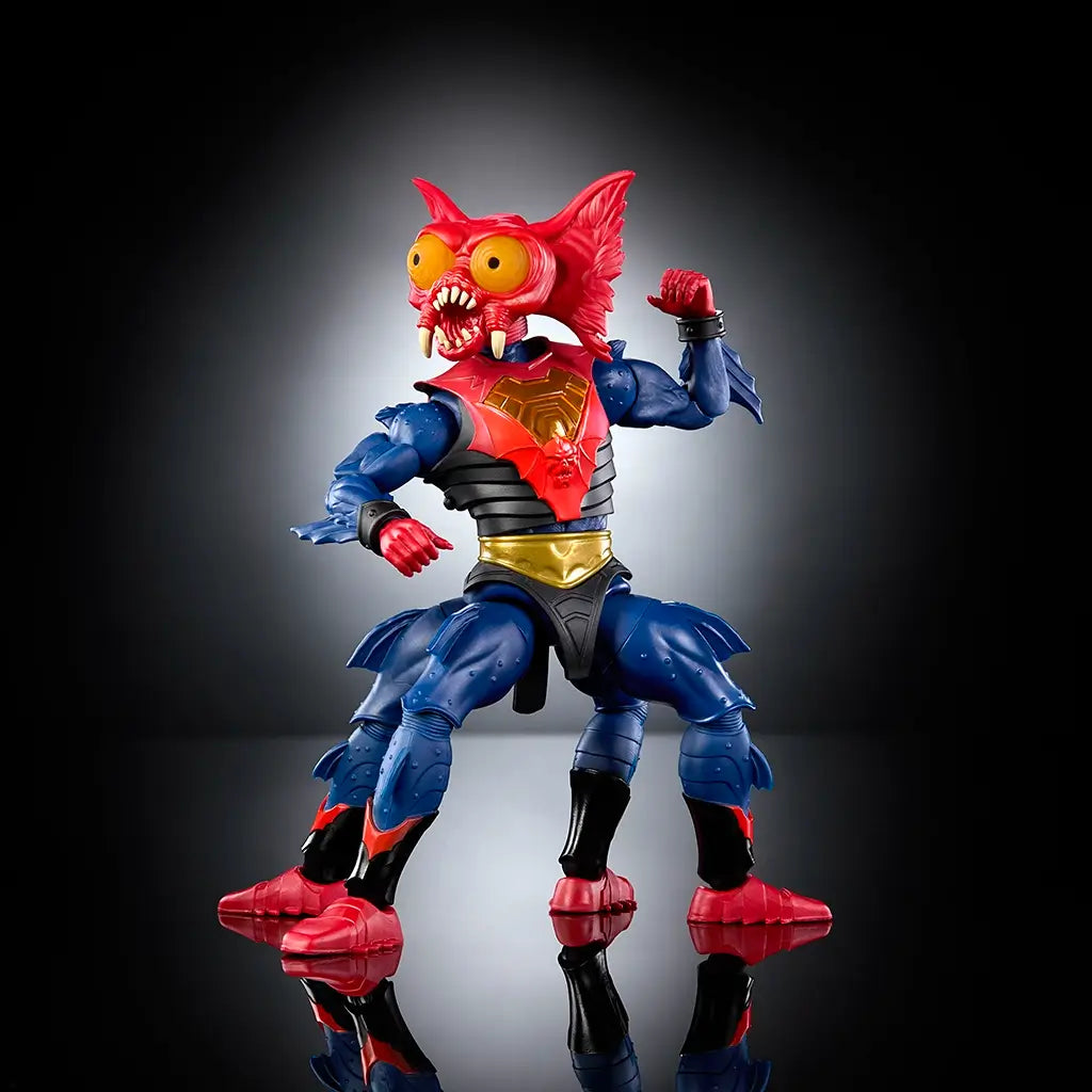Mantenna Masters of the Universe New Eternia action figure posed dynamically in red, blue, and gold plastic, showing wide stance, articulated joints, expressive insect head, and staff weapon against a dark studio-style background.