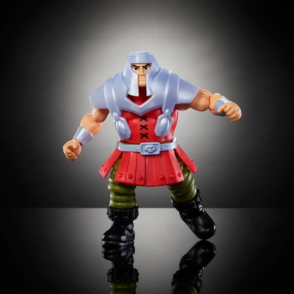 Ram Man action figure from Masters of the Universe wearing silver armor, red skirted tunic, and green pants, standing with fists clenched on reflective black surface.