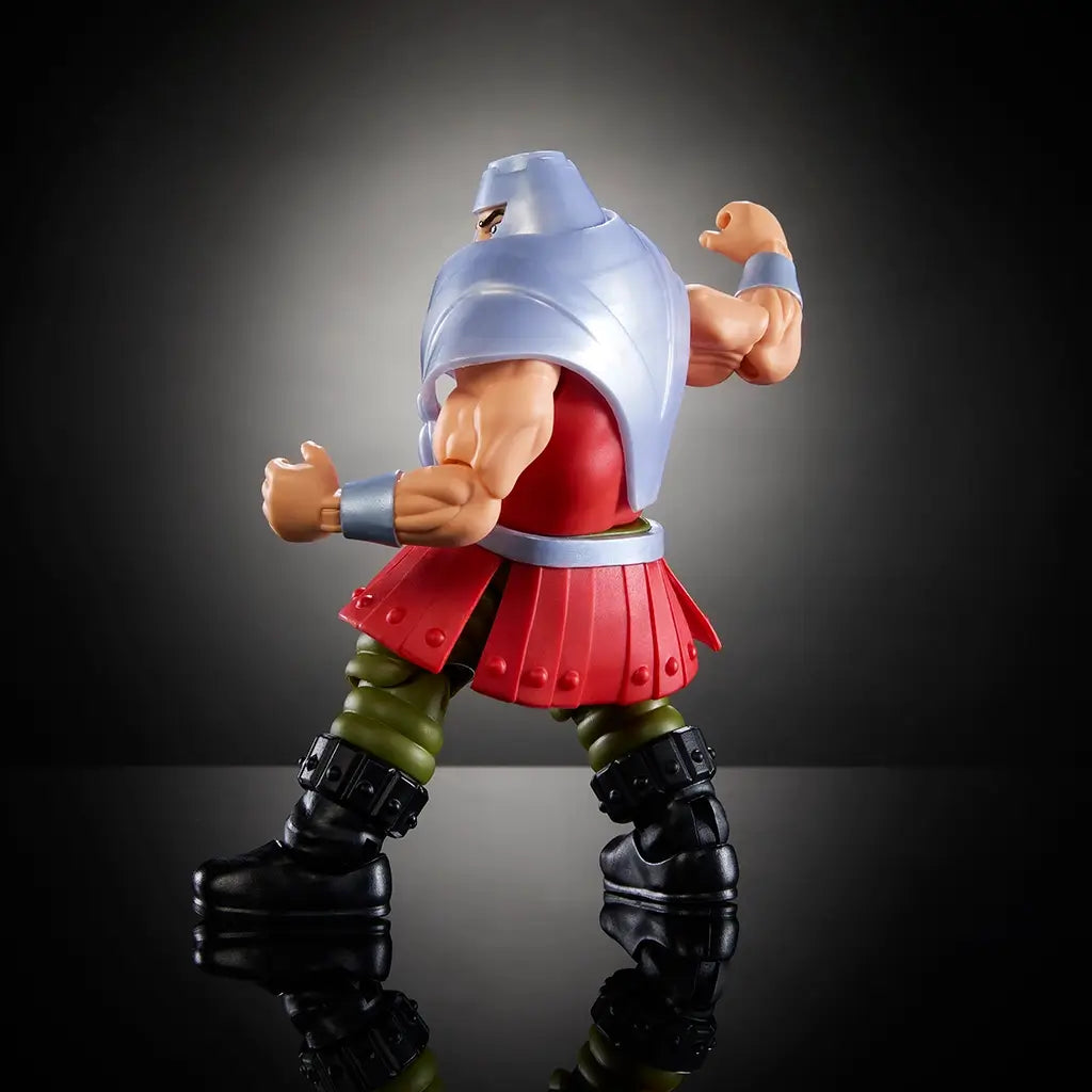 Side view of Ram Man Masters of the Universe action figure in silver helmet and armor, red tunic, and green pants, posed as if throwing a punch.