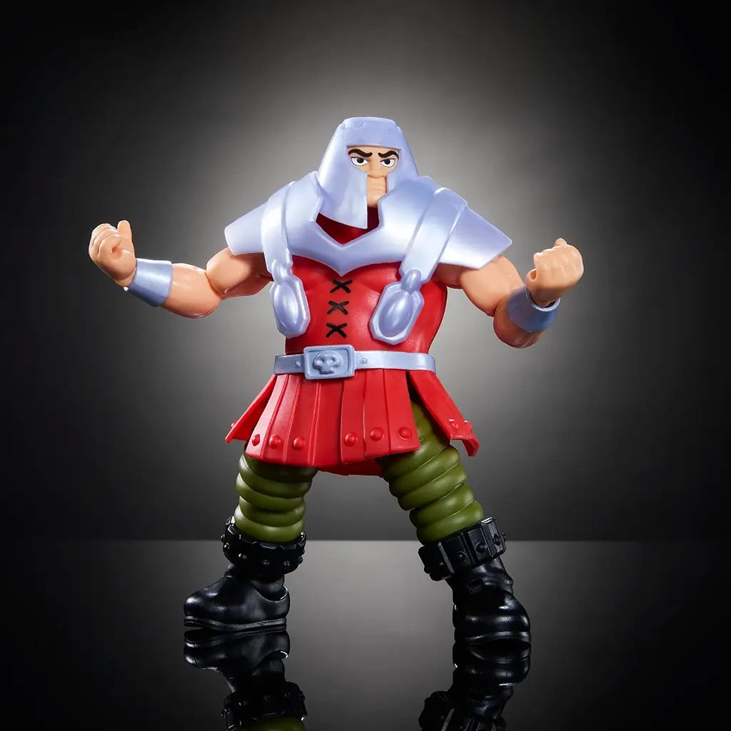 Ram Man Masters of the Universe action figure with muscular build, silver armor, and red tunic, standing ready for battle with arms flexed on black reflective surface.