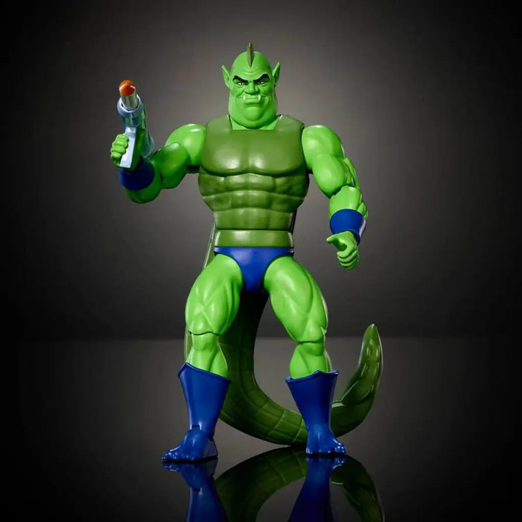 Front view of Whiplash action figure from Masters of the Universe Origins, showing green sculpted muscles, armored chest texture, blue boots and wristbands, fierce facial expression, posed on a dark studio backdrop.