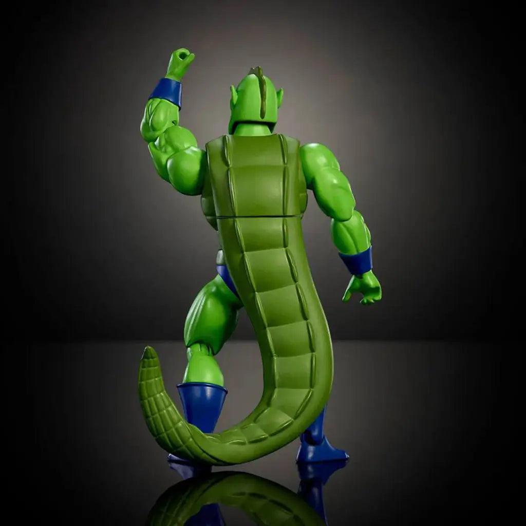 Rear view of Whiplash action figure highlighting long segmented green tail, muscular back sculpt, blue boots, articulated joints, and dynamic stance photographed from behind on a dark studio background.