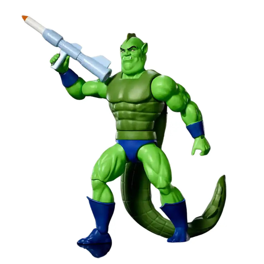 Whiplash action figure from He-Man and the Masters of the Universe Origins, featuring bright green plastic skin, muscular reptilian body, textured tail, blue boots and trunks, holding a gray blaster accessory on a clean white background.