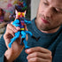 Person holding Masters of the Universe Mantenna action figure, showing red bug-like head, bright yellow eyes, and articulated blue limbs in close-up indoor setting.
