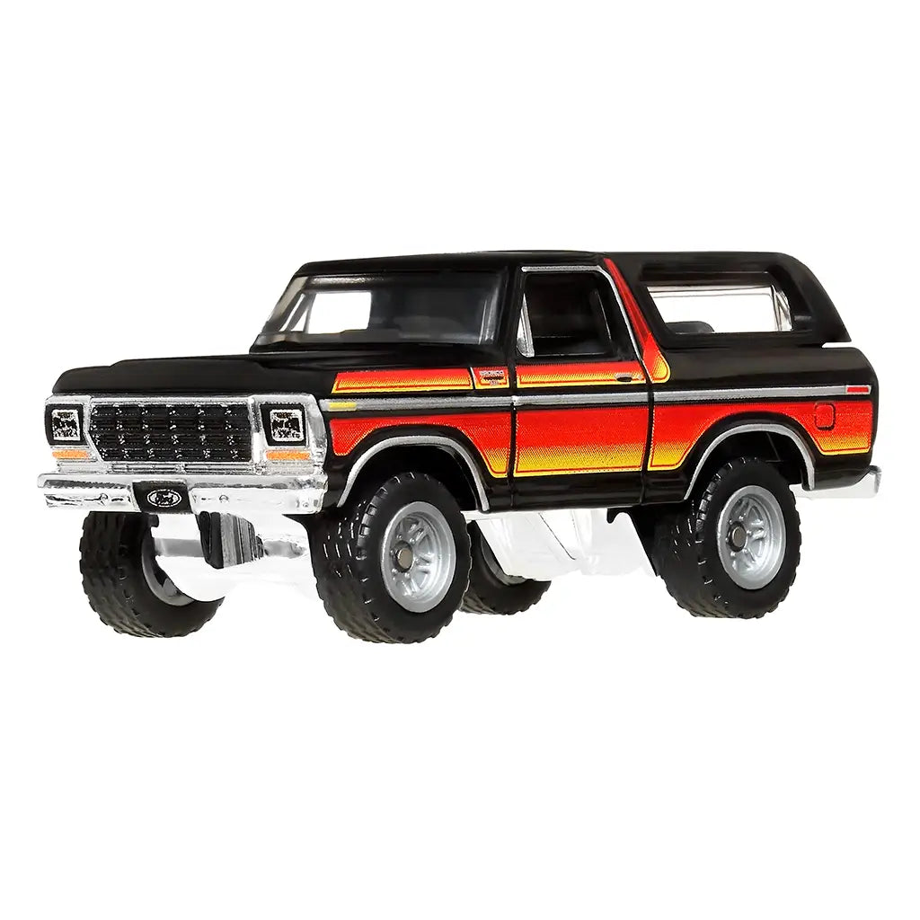 Die-cast Matchbox 1978 Ford Bronco in glossy black with chrome bumper, large off-road tires, and bold red-to-orange gradient stripes, shown at front angled perspective.