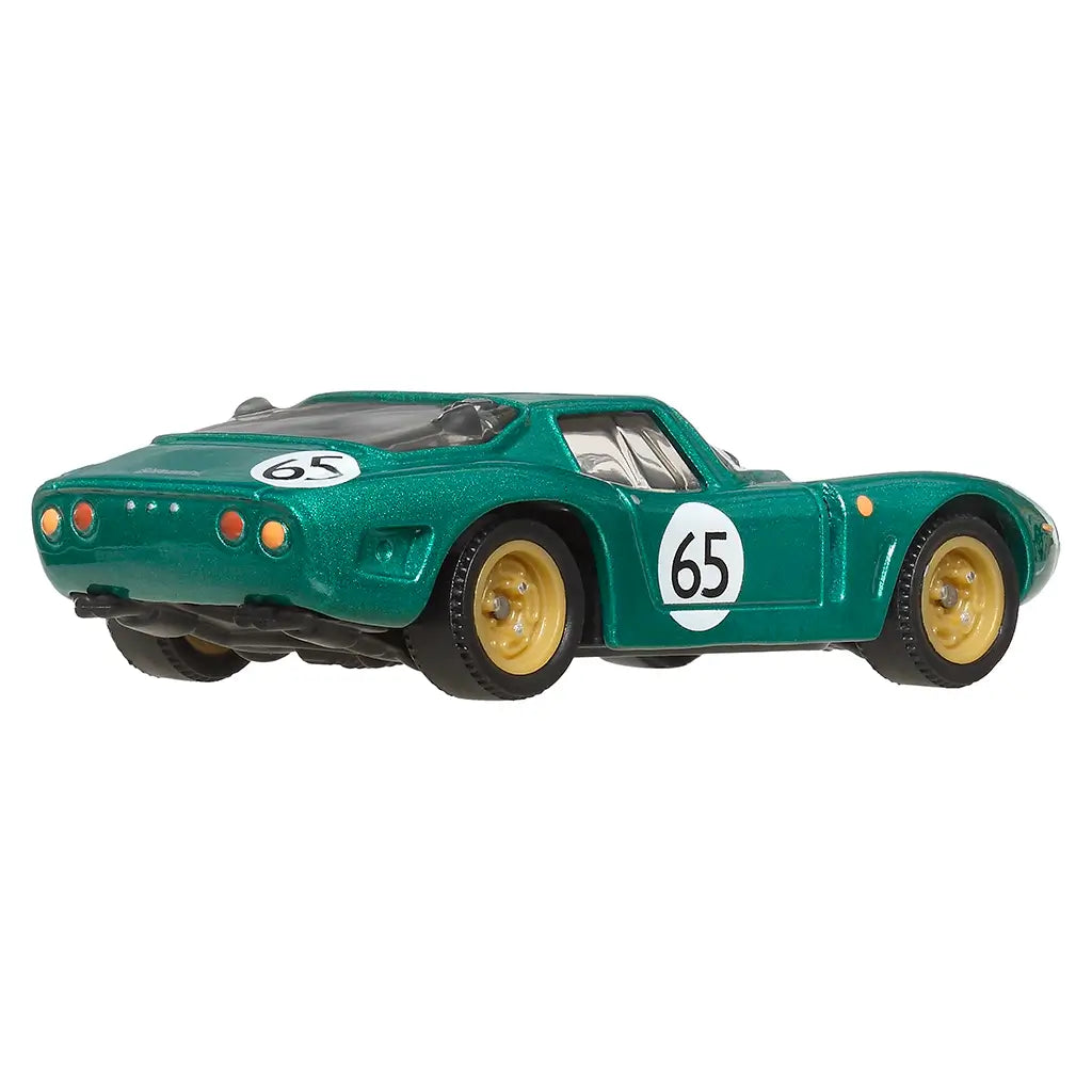 Rear angled view of Matchbox Bizzarrini 5300 GT Corsa Revival die-cast car in metallic green with gold wheels, white number 65 racing decals, and detailed tail lights.