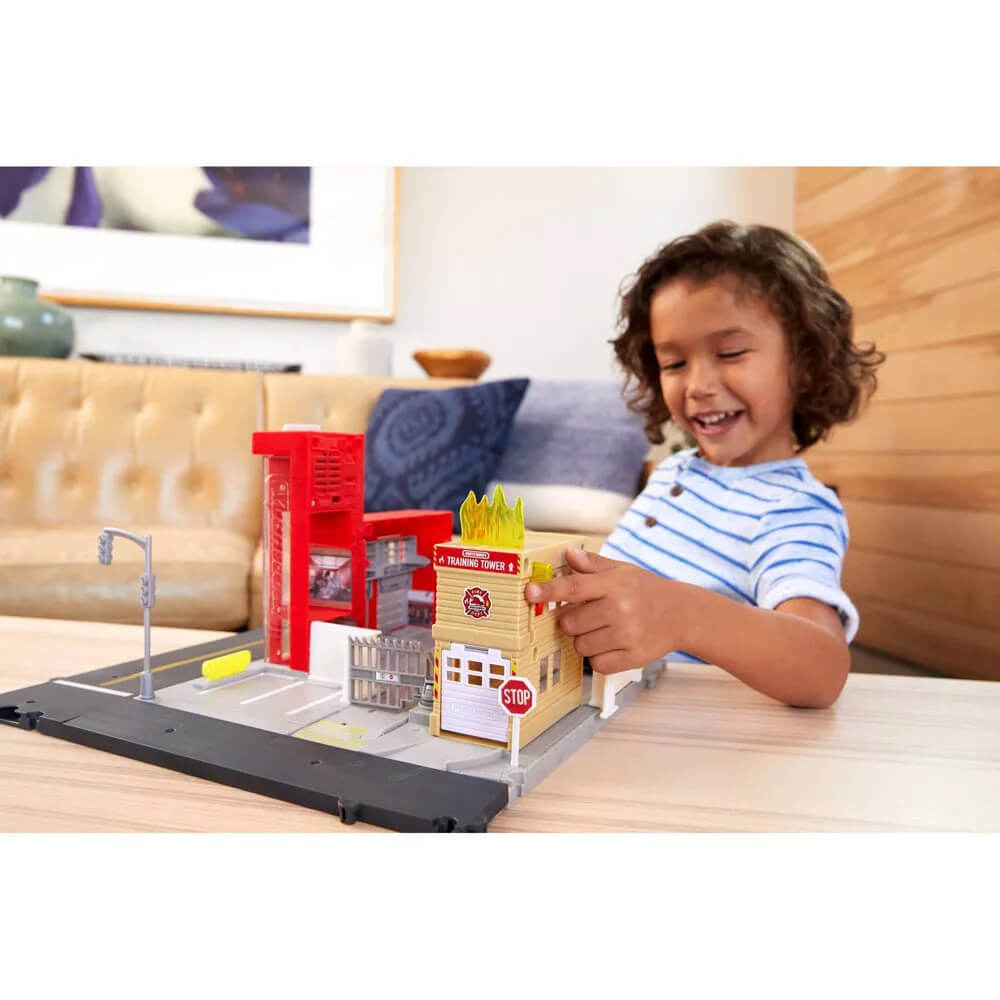 Kid playing with MATCHBOX ACTION DRIVERS Matchbox Fire Station Rescue Playset