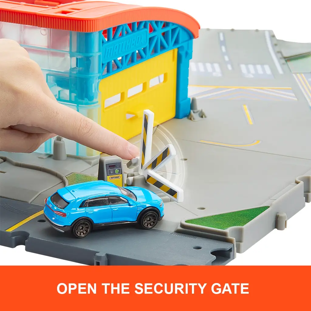 Matchbox Airport Takeoff Adventure playset with a hand pressing a security gate button to open striped barriers as a blue toy SUV drives toward the yellow hangar.