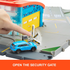 Matchbox Airport Takeoff Adventure playset with a hand pressing a security gate button to open striped barriers as a blue toy SUV drives toward the yellow hangar.