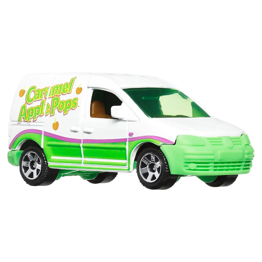 Angled view of Matchbox Volkswagen Caddy Delivery die-cast van painted white and green with purple stripe, Caramel Apple Pops logo, tinted windows, and chrome-style wheels.