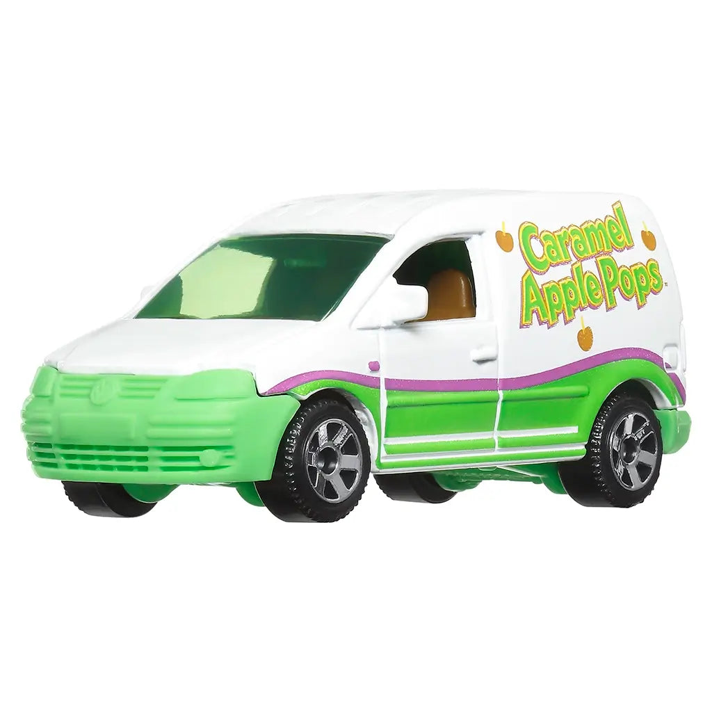 Side view of Matchbox Volkswagen Caddy Delivery van in green and white with Caramel Apple Pops candy branding, featuring playful apple graphics and black tires with silver rims.