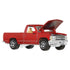 Red Matchbox 1995 Chevy C1500 diecast truck viewed from front angle with detailed chrome grille, tan interior, black wheels, and open hood revealing engine detail.