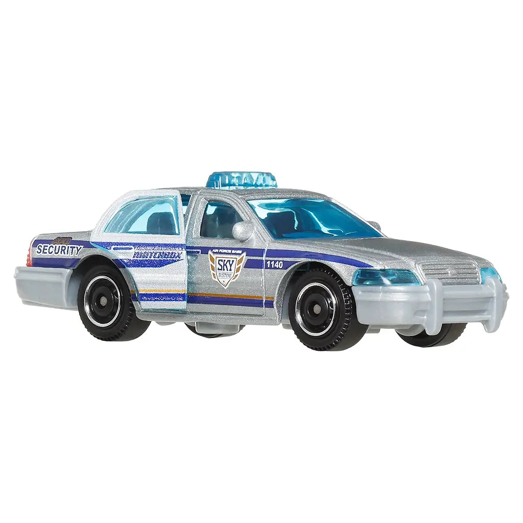 Side angled view of Matchbox silver Ford Crown Victoria toy car with opening front door, blue interior windows, security graphics, SKY series badge, and molded police-style details.