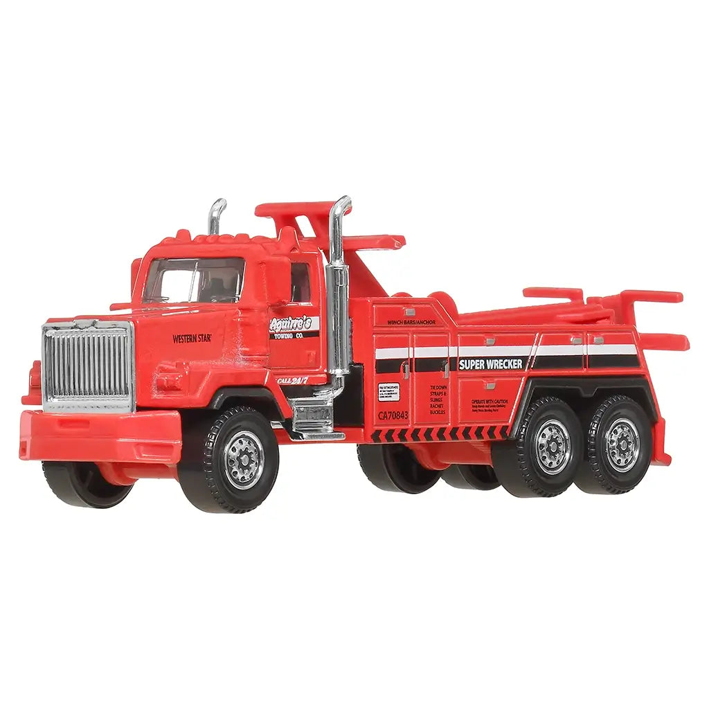 Red Matchbox Western Star 6900XD die-cast tow truck with silver grille, black accents, and triple rear axles, shown angled front view on clean white studio background.