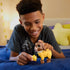 Smiling child plays with Disney Wish Valentino goat toy and glittery yellow Star accessory on a bed, demonstrating button-activated sound feature.