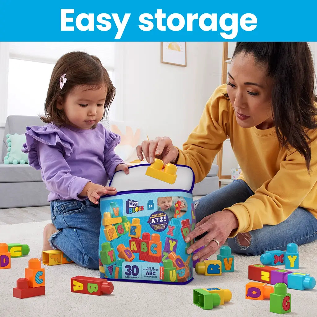 Adult and toddler putting colorful lettered Mega Bloks into a blue zippered storage bag, highlighting easy cleanup and parent-child interaction.