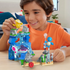 Child in orange shirt plays with Mega Pokémon Aquatic Adventure building set, featuring colorful water-themed blocks with Squirtle, Psyduck, and Finneon figures on a wooden table.