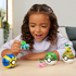 Smiling young girl plays with Mega Pokémon Bulbasaur figure alongside Hoppip, Turtwig, and colorful Poké Ball toys, showing creative building and interactive fun.