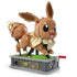Angled view of smiling brown Mega Pokémon Eevee model on a decorative gray base with exposed green gears inside, posed mid-step for display.