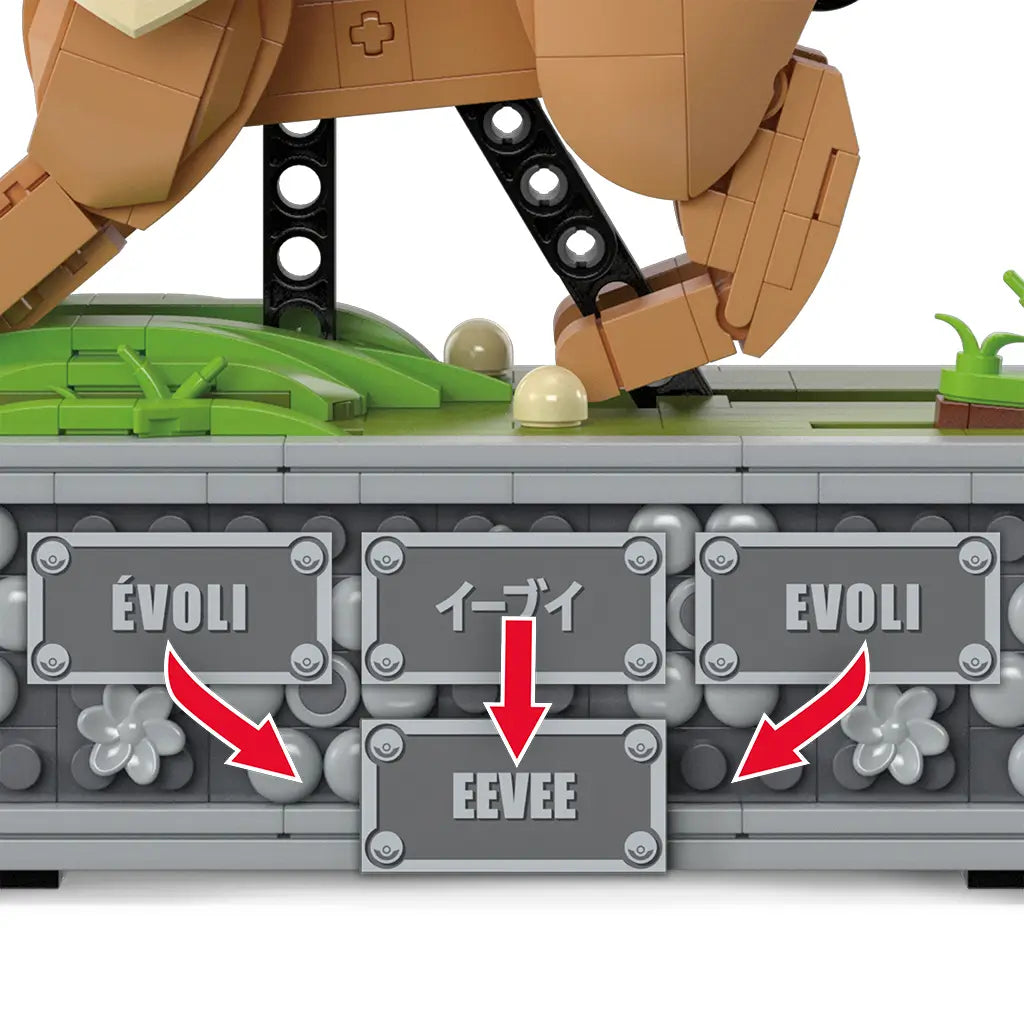 Close-up of Mega Pokémon Eevee base showing interchangeable gray nameplates labeled Évoli, イーブイ, Eevee, and Evoli in different languages.