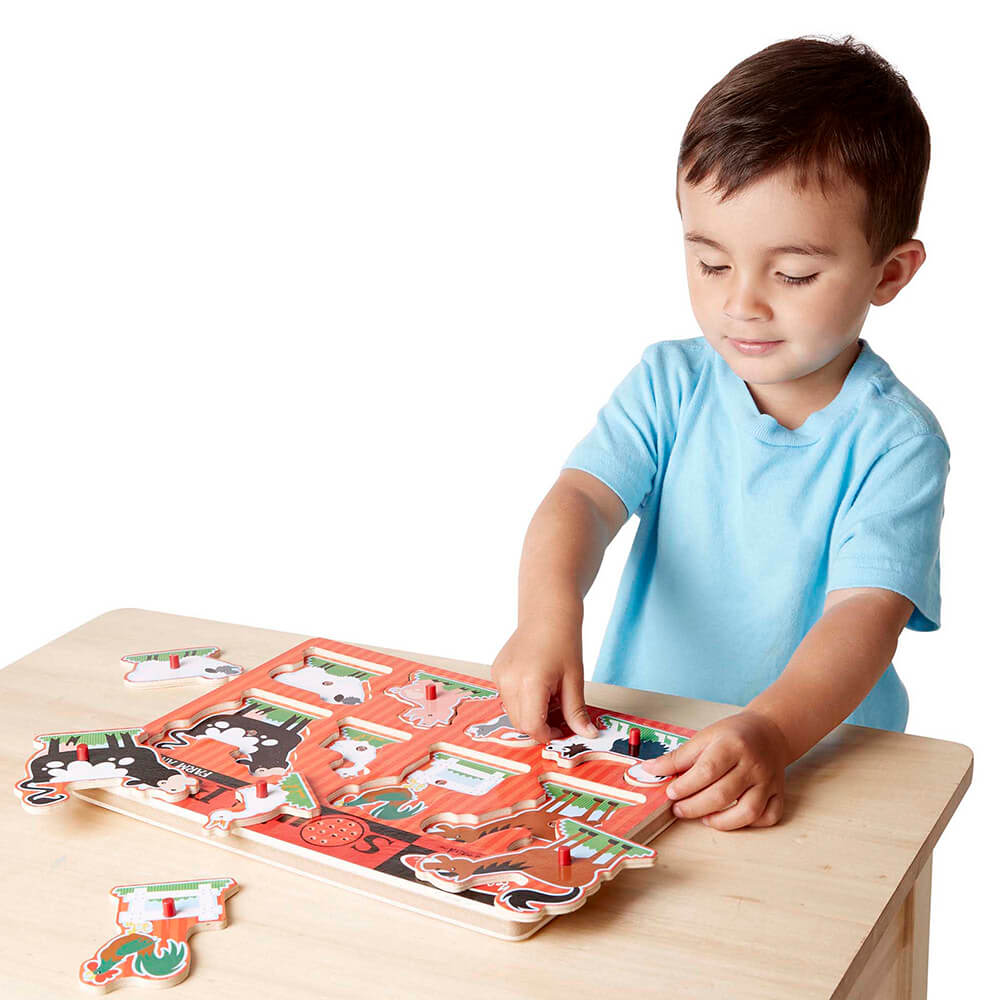 Little boy playing with the Melissa and Doug Farm Animals 8 Piece Sound Puzzle