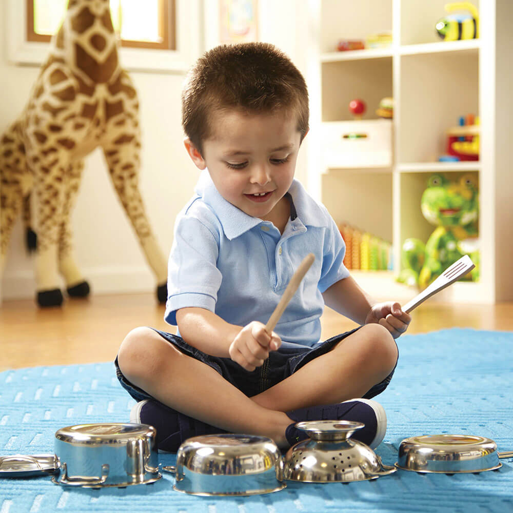 Picture of a boy using the Melissa and Doug Let's Play House! Stainless Steel Pots & Pans Play Set to play drums