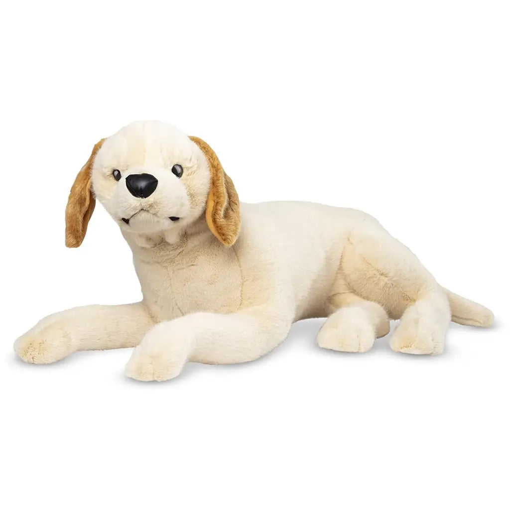 Melissa & Doug lifelike plush yellow Labrador puppy toy in cream fabric with golden brown ears, soft texture, and realistic details, shown lying down as a cuddly companion for kids.