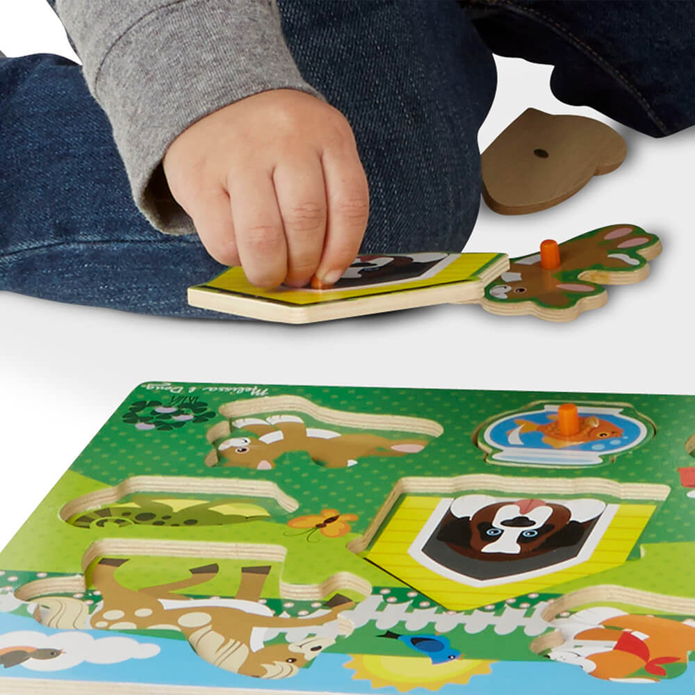 little hands picking up pieces of the Melissa and Doug Pets 8 Piece Peg Puzzle