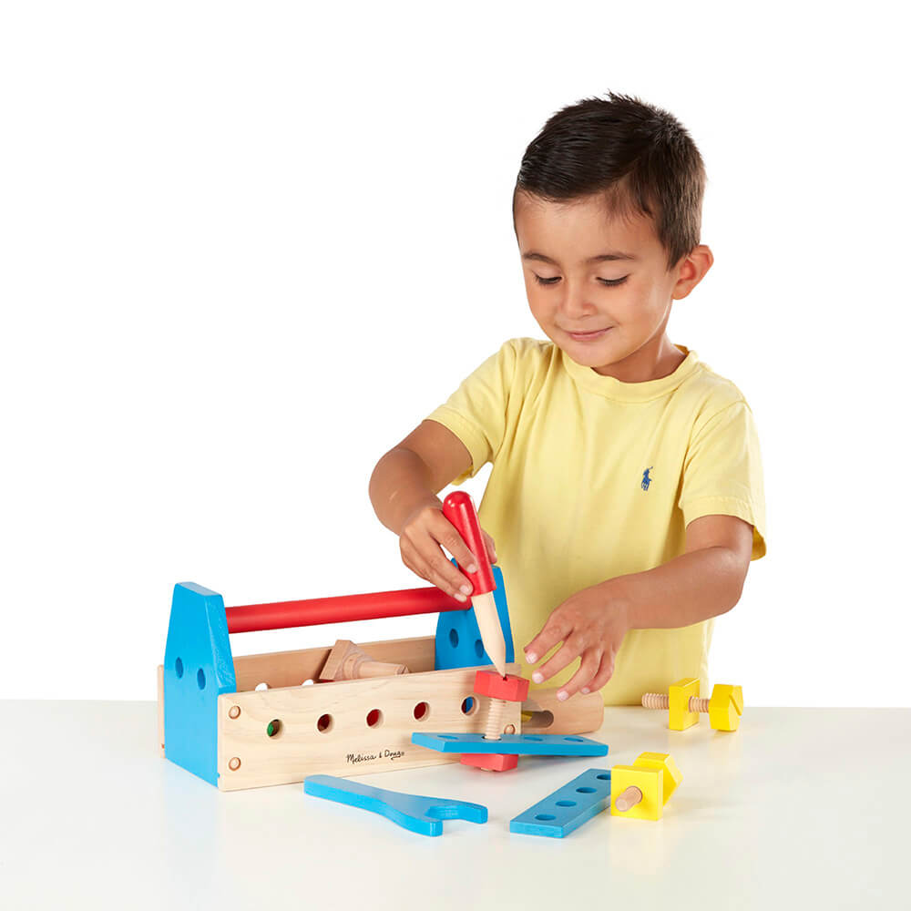 Boy playing with the Melissa and Doug Take-Along Tool Kit Wooden Toy building 