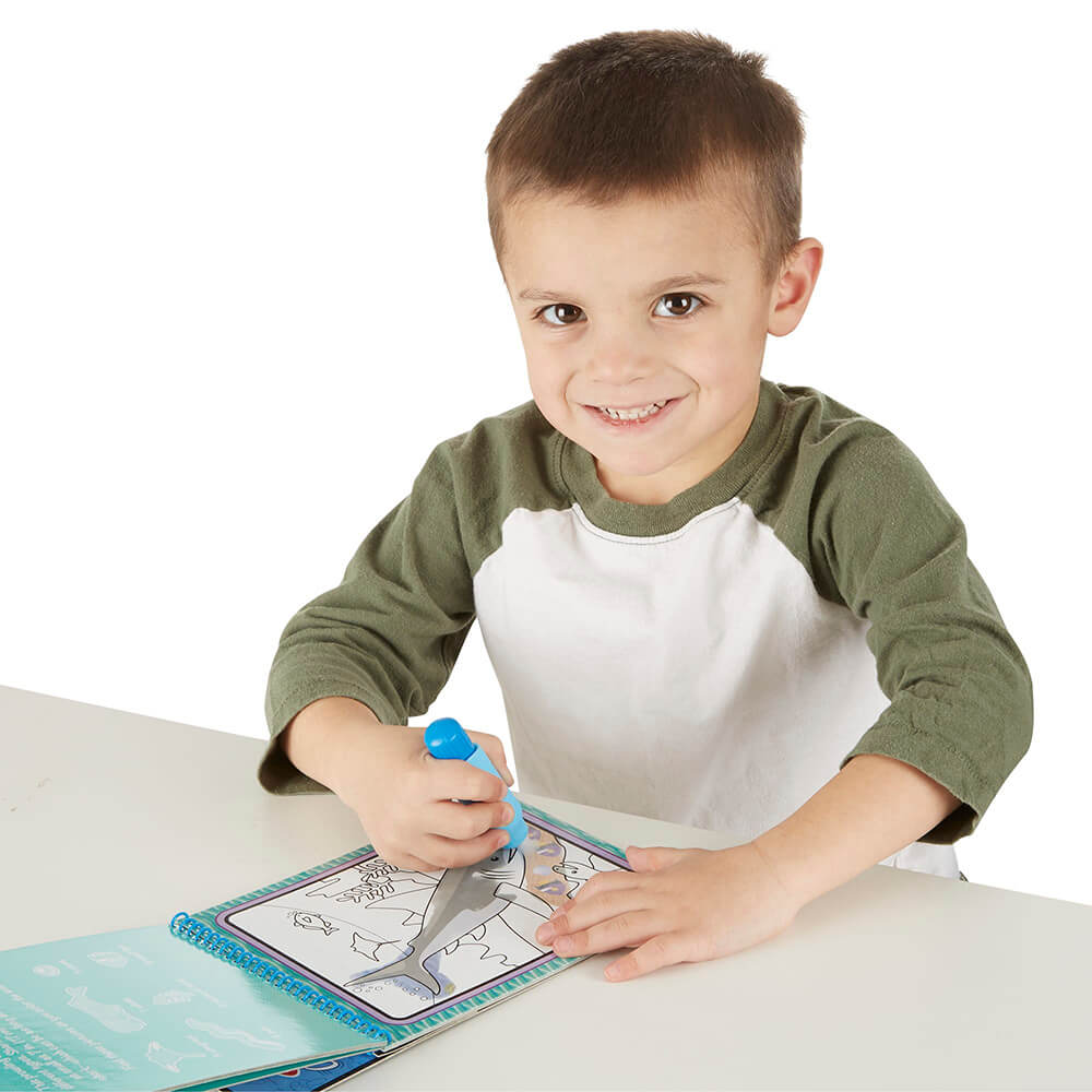 Boy coloring the Melissa and Doug Water Wow! Under the Sea Water-Reveal On the Go Travel Activity Pad
