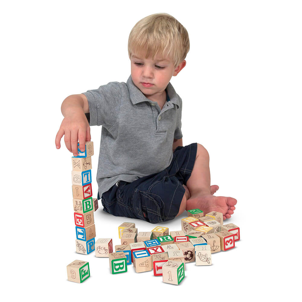 Boy playing with Melissa and Doug Wooden ABC 123 Blocks stacking them up