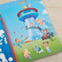 Paw Patrol puffy sticker scene showing the lookout tower with characters, animals, and accessories arranged on a sunny blue sky background with green grassy foreground.