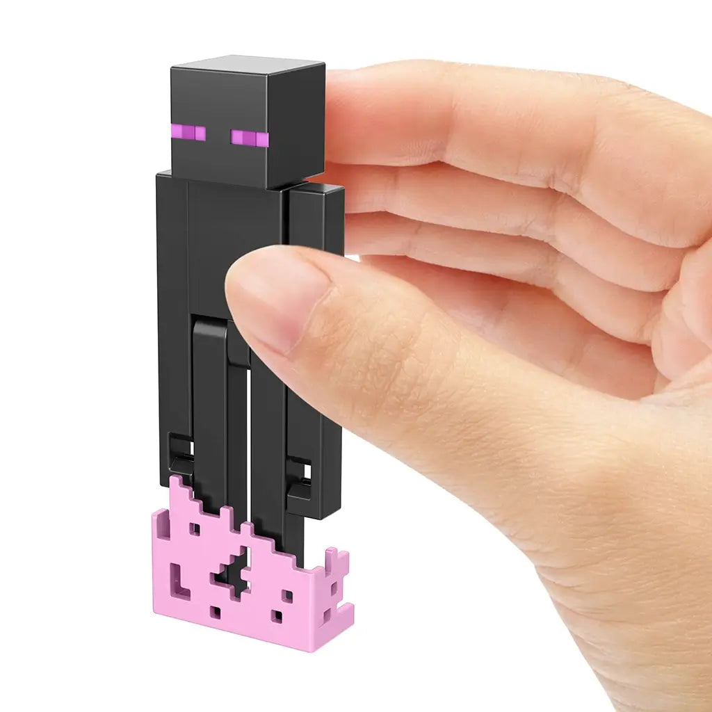 Hand holding Minecraft Enderman 3.25-inch action figure standing on pink teleportation base, showcasing detailed pixelated design.