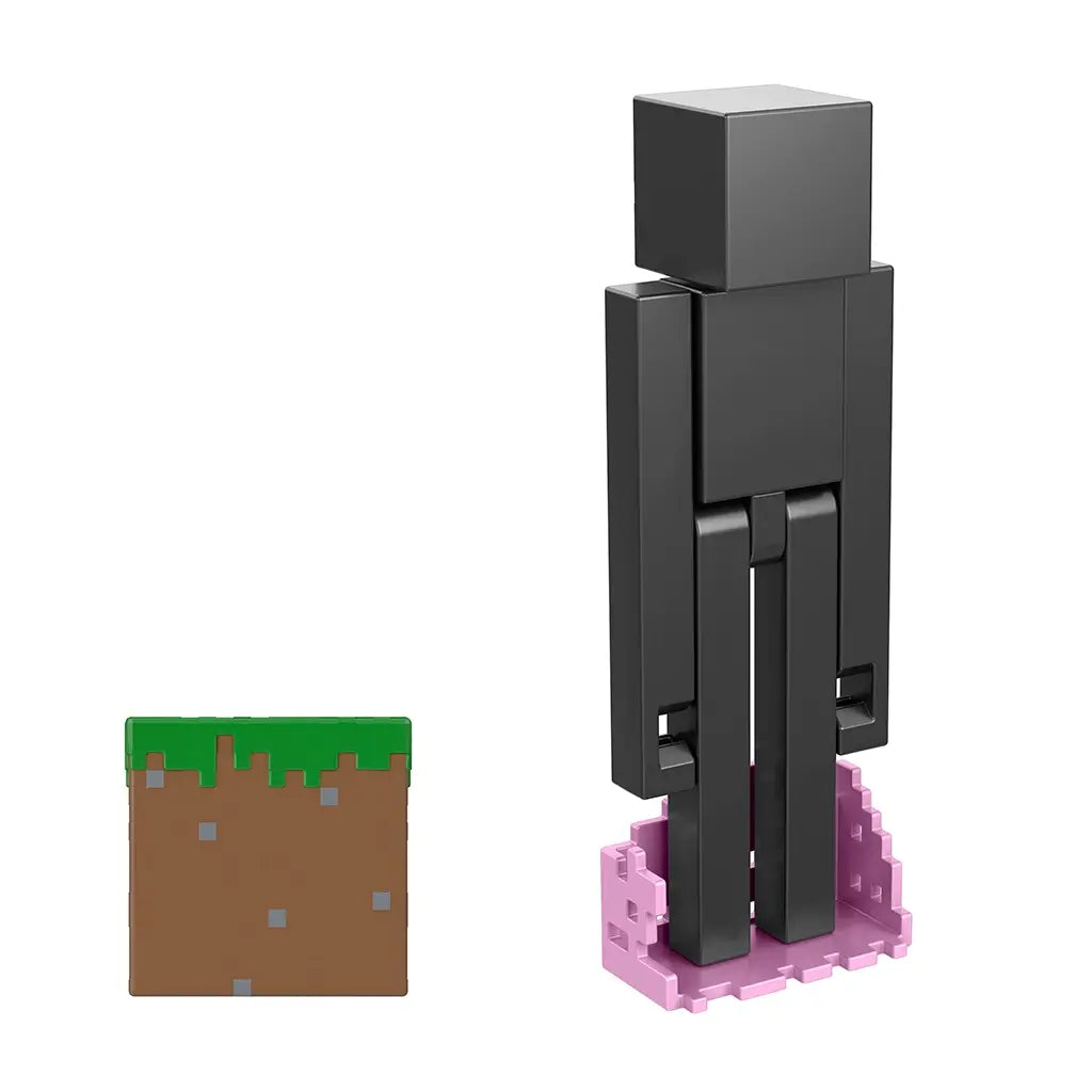 Rear angled view of Minecraft Enderman 3.25-inch action figure, standing on pink teleportation effect base with grass block accessory nearby.