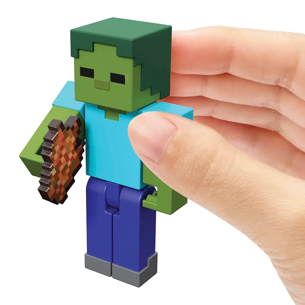 Hand holding Minecraft Zombie 3.25-inch action figure with pixelated design, holding rotten flesh accessory for roleplay fun.