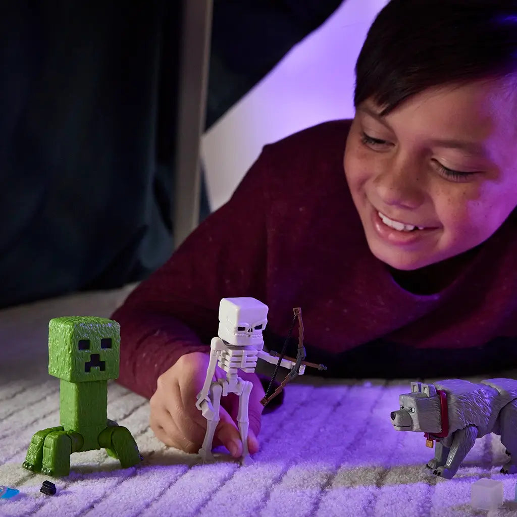 Child playing indoors with Minecraft Creeper, Skeleton, and Wolf figures, smiling while posing the blocky action toys on a carpet under soft ambient lighting.