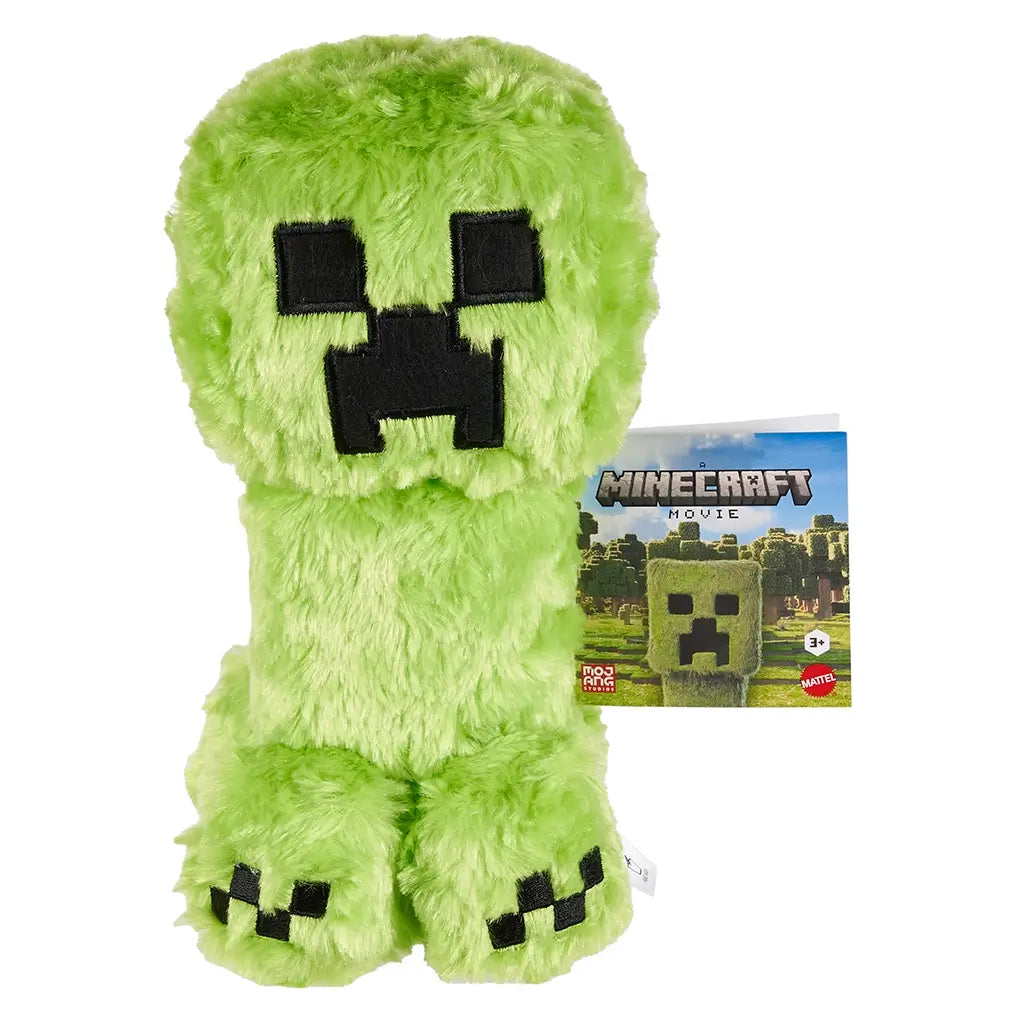Minecraft Creeper plush toy, bright green faux fur with black stitched pixel face, shown with branded Minecraft Movie tag against a white background.
