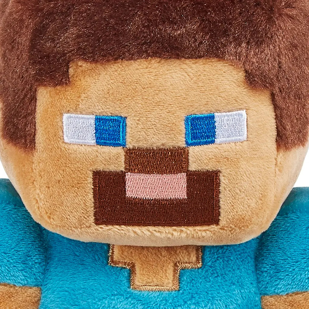 Minecraft Steve plush close-up showing tan and brown stitched fabric, square embroidered eyes and beard, pixelated facial shape, highlighting character details on a soft toy against a plain white background.