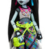 Close-up of Frankie Stein doll’s outfit featuring mesh crop top, plaid multicolor pants, neon green belt with accessories, and detailed black and silver wristbands.
